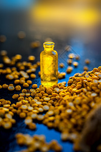 在小玻璃瓶里 和一些生黄扁豆一起在木质表面上 喷出鸡尾酒的精华产品花生瓶子营养按摩身体玻璃化妆油植物油食物图片