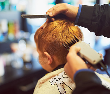 一个男孩在理发店理发时剪头发的特写镜头 拍到一张照片图片