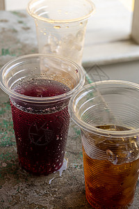 软饮料和可支配塑料玻璃杯中的冰野餐饮料甜水桌子果汁橙子红色汽水杯子玻璃图片