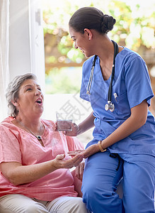 这会让您立刻感觉好些 一名护士正在给一位老年患者服药和一杯水背景图片