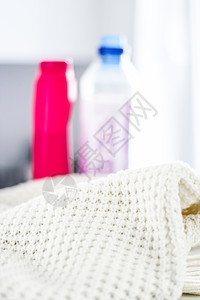 温暖编织的衣服和液体洗衣洗涤剂奢华纺织品手工塑料毛衣标签服装壁橱卫生瓶子图片