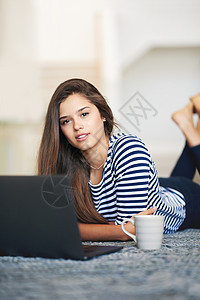 我最喜爱的剧目 一位年轻女人用笔记本电脑 躺在家里地板上的肖像图片