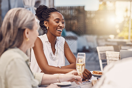 香槟 庆祝活动和快乐的女性在餐厅或社交活动中在一张有镜头光晕和美食背景的餐桌上用餐 面带微笑的黑人女性与朋友一起吃饭聊天图片