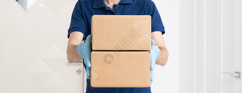 提供T恤衫 防护面具和手套的送货人员订购食品 并在白色背景上装箱 (b) 保护面罩和手套图片