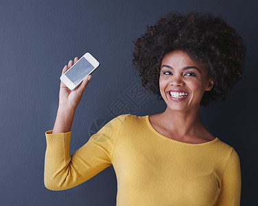 工作室拍到一个年轻女人用灰色背景拿起她的手机的片子 这段影片是一部你不想错过的应用程序图片