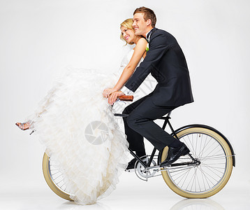 快乐 婚礼和情侣在白色背景下骑自行车 一起结婚后 爱 穿着礼服和西装的年轻新娘和新郎 在婚姻幸福或幸福中骑自行车图片