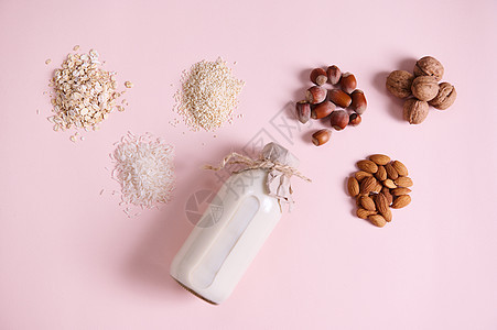 静物 有益健康的种子 坚果 豆类 杏仁 榛子 核桃 芝麻 大米 燕麦片和一瓶植物奶图片