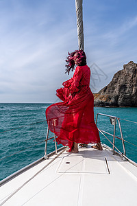 夏日在游艇上穿着红色礼服的中年女子 有吸引力的中年妇女 豪华暑假冒险 户外活动海滩帆船幸福双体女士微笑闲暇假期巡航旅行图片