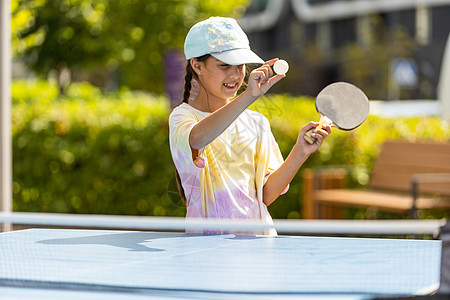 少女在打乒乓球 她手里握着球和电击手 在院子里户外玩桌球网球球拍孩子们反手玩家闲暇爱好竞赛专注娱乐活动图片