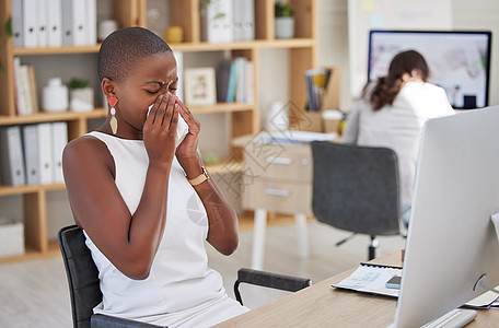 在办公室工作时患有流感 感冒或 covid 的生病公司员工 患有鼻窦炎或过敏 打喷嚏和工作时感觉不适 擤鼻涕和不舒服的年轻专业人图片