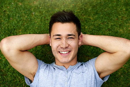 一个英俊的年轻男子在草地上放松的肖像 长得一清二楚图片