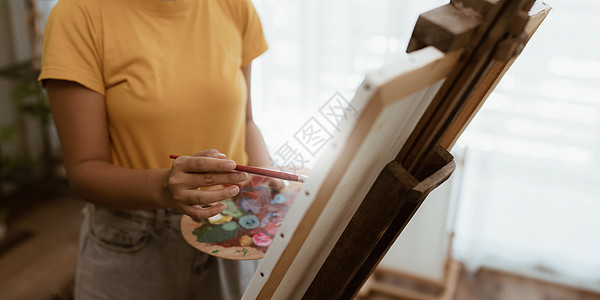 在讲习班上在画布上绘画的快乐年轻女艺术家女性艺术印象派阁楼工具女士创造力女孩刷子画家图片
