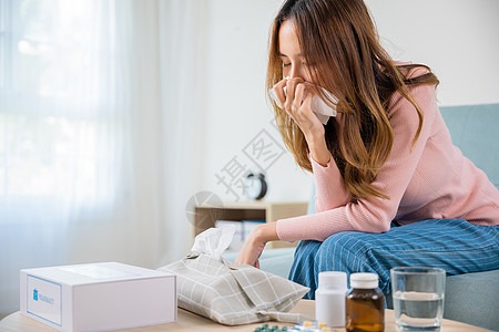 亚裔年青冷冰冷生病的女孩在沙发上用纸纸打喷嚏女士症状药品悲伤疫苗疼痛药店病人疾病发烧图片