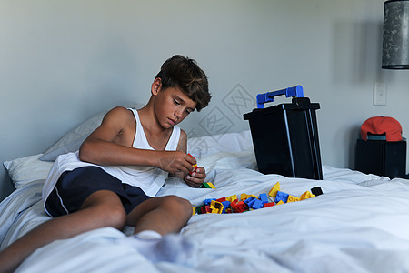 儿童游戏孩子们通过玩耍学到很多东西 一个小男孩在家里的床上玩玩具背景