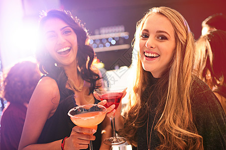 我们最喜欢的周末聚会点 两个年轻女子的肖像 在一个派对上喝鸡尾酒图片