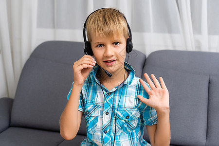 在家里的视频通话中 在耳机中特写白人小男孩的屏幕视图 远距离耳机学习中小孩的爆头肖像在电脑上有网络摄像头虚拟课程孩子活动班级技术图片
