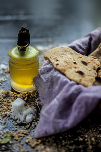 在篮子容器中拍摄 bhakri 在黑色表面上的小玻璃瓶中撒上一些小麦粉和一些食用油 传统古吉拉特面包 Bhakri 的特写镜头香图片