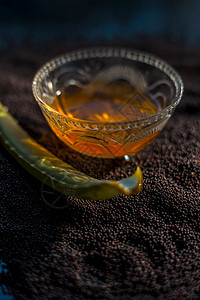 芥子种子为皮肤发光而用面罩遮住 表面涂有芥子籽 aloe Vera 和黑面玻璃碗中的一些蜂蜜排毒色素沉着香料按摩酵素果汁芸苔治疗图片