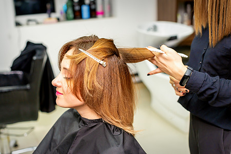 女客户在美容院理发 年轻女性喜欢换新发型 她的头发也不错理发师工作微笑客厅裁剪职业梳子造型师服务女孩背景图片