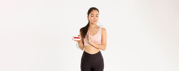 积极的生活方式 健身和幸福理念 坚定的亚洲女运动员拒绝甜食 在节食期间戒掉垃圾食品 减肥 拒绝吃蛋糕 站在不情愿的白人背景下糖果图片