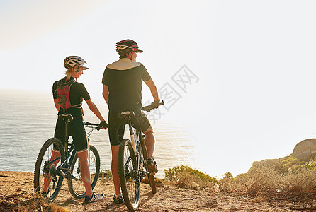 一对年轻夫妇在骑自行车时 仰慕山顶的风景 而他们却坐着脚踏车图片