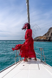 夏日在游艇上穿着红色礼服的中年女子 有吸引力的中年妇女 豪华暑假冒险 户外活动假期海滩女性船长幸福双体巡航血管女士奢华图片