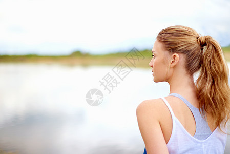 一个人去思考吧 做瑜伽时 一个年轻女人在湖边看湖的后视镜头图片