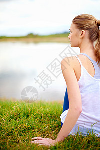 在做瑜伽时 一位年轻女子在湖边看着湖的后视镜拍到的照片图片