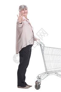 拿着购物车的老太太带着笑容看着你老年成人福利广告牌购物顾客工作室女性大车销售背景图片