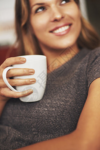 在家里放松 现在这是我的茶杯 一个年轻女人在家享受热饮喝着图片