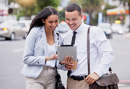 5g 平板电脑互联网和社交媒体直播一对夫妇在城市下班后的观看 快乐的工作朋友或伙伴面带微笑地看着城市街道上的模因 网络或博客内容图片