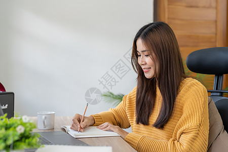 亚洲女学生在线观看课程并远程学习 年轻女子在视频通话中做笔记 听女老师讲课 与老师和学生进行视频会议电脑商务家庭作业教育班级职场图片