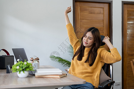 快乐的女商务人士在工作场所热身身体和肌肉 对完成的工作感到满意 微笑的女员工在电脑屏幕前休息 工作中的幸福感 生产力和幸福感图片