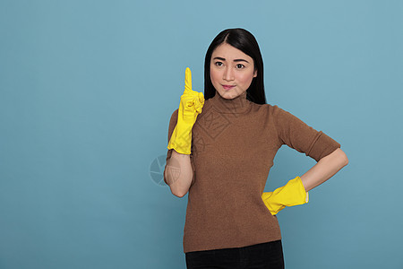 带着黄色手套 向上指着手指笑笑高兴的像做家务工人一样喜悦地微笑图片