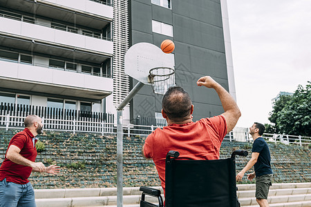 残疾人与两个朋友一起扔篮子图片