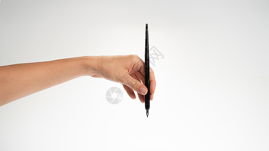 女人左手拿着白背景的书写笔 手势落到墨水井里 左图片