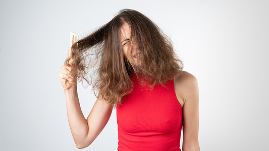 女人伤痛时的阴暗 由不守规矩的缠结头发和梳子混合而成的复杂组合背景图片