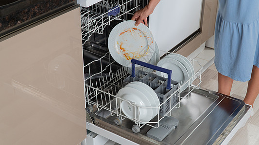 女人的手把脏盘子放在洗碗机里家庭洗衣机烦恼女性清洁剂厨房家用电器菜肴家务电器图片