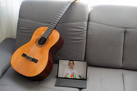 家庭背景舒适的沙发上听声吉他和数字片 在线音乐课 学习演奏或写歌和爱好概念在网上播放笔记横幅吉他手药片治疗歌曲孩子闲暇女孩乐器图片