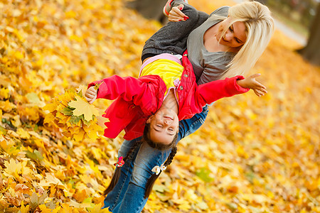 幸福家庭 母幼女儿在大自然户外的秋天散步时玩抱抱游戏乐趣女士母性公园女性快乐叶子女孩童年父母图片