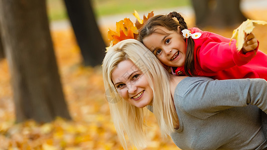 幸福家庭 母幼女儿在大自然户外的秋天散步时玩抱抱游戏母性女士婴儿女孩女性喜悦森林父母乐趣叶子图片
