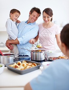 你又做了一次 亲爱的 看起来很好吃 一个幸福的家庭在厨房里一起做一顿丰盛可口的饭菜图片