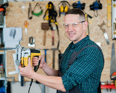 一名男子在车间用电锯锯木头的肖像工艺拼图机器手工硬木材料工作台工作男性刀刃图片