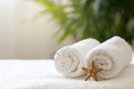 旅馆房间床上的白色毛巾滚动按摩桌子棉布棕榈淋浴酒店浴室架子棕色治疗图片