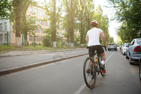 城里的男骑自行车者碎石城市头盔旅行安全运输自行车活动运动车辆背景图片