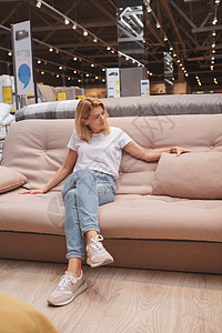 在家具超市购物的女年长妇女沙发休息价格销售商业购物者顾客商品床垫零售图片