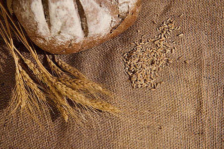 小麦耳朵 部分看家制作的全粮食面包和谷类谷物 散布在一块薄布桌布上图片