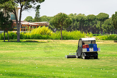 高尔夫球场和收集高尔夫球的高尔夫球车 高尔夫俱乐部练习场上的 Ballpicker机器草地火鸡卡车驾驶大车草皮集电极工作拖拉机图片