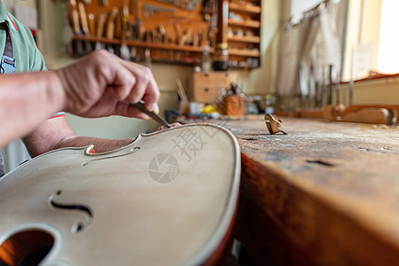 润滑油雕刻着小提琴前部外侧的形状音乐制造商作坊琴师工具职业组装敬业乐器精神图片