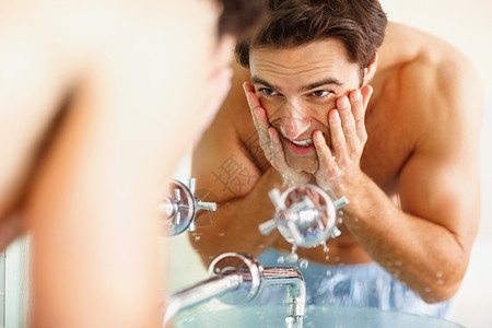 快乐的年轻人在洗脸盆洗脸 微笑的年轻人在浴室洗脸盆洗脸图片
